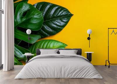  A tight shot of a green plant against a yellow backdrop The middle ground is occupied by the leafy foliage Wall mural