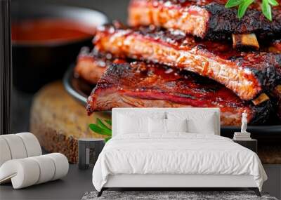  A tight shot of a plate piled high with ribs on a weathered wooden table In the background, a petite bowl holds a savory sauce Wall mural