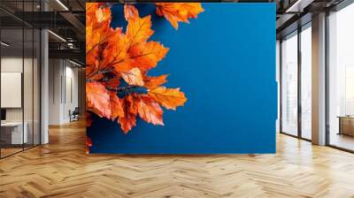  An orange-red branched tree against a blue backdrop, featuring a blue sky in the distance Wall mural