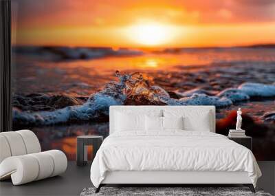  Over the ocean, the sun sets, casting an orange and blue blur in the sky Waves crash against the shore, and a rock stands out in the foreground Wall mural