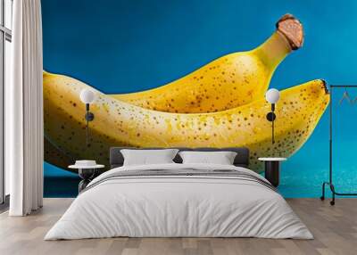  Two bananas resting together on a blue, speckled surface Wall mural