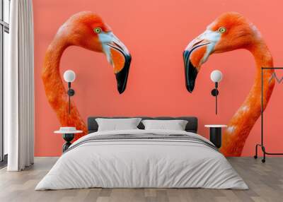  Two flamingos face opposite directions against a uniform pink backdrop One faces forward, while the other faces backward Wall mural