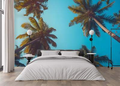 Palm trees on a Mexican beach during summer, create a vacation dadcore vibes. Scene with several palm trees against a weathercore blue horizon, nature-based patterns from a low angle perspective. Wall mural