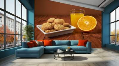 Homemade orange-flavored cookies accompanied by a glass of fresh orange juice Wall mural