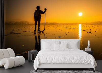 Ice hockey player on a frozen lake at sunset Wall mural