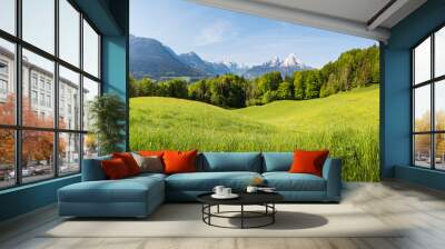 Scenic panoramic view of idyllic rolling hills landscape with blooming meadows and snowcapped alpine mountain peaks in the background on a beautiful sunny day with blue sky and clouds in springtime Wall mural