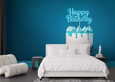 White happy birthday cake with teal ganache over a blue background Wall mural