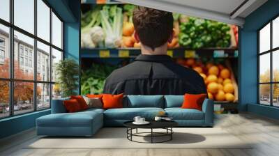 A man attentively examines vibrant vegetables  Wall mural