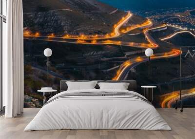 mountain road with trailing lights at night Wall mural