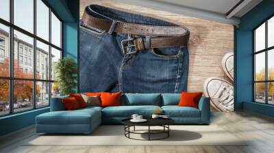 Blue jeans with leather belt and dirty white sneaker shoes on t Wall mural