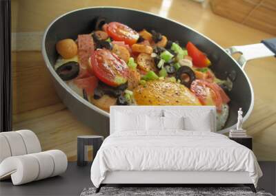 Fried egg with sausage ,tomatoes and olives in a pan on wooden t Wall mural