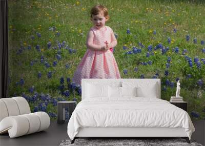 Young Toddler Girl Picking Flowers in Field of Blue Bonnets in Texas Wall mural