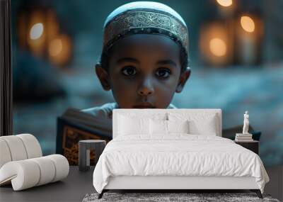 A young Muslim boy reading the holy book Quran with devotion and spirituality. Wall mural