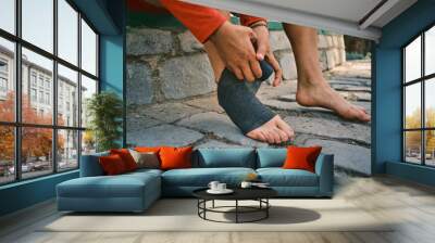 latina woman putting bandages on her feet to protect herself before going to her soccer match in latin america Wall mural