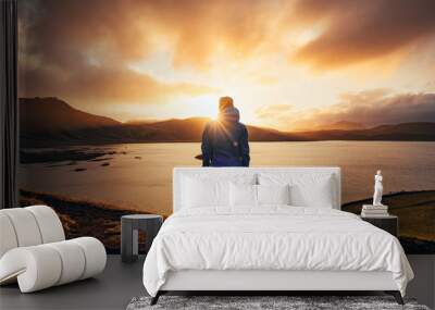 Man standing in blue jacket looking at spectacular sunset over frostadavatn lake in Landmannalaugar in Iceland Wall mural