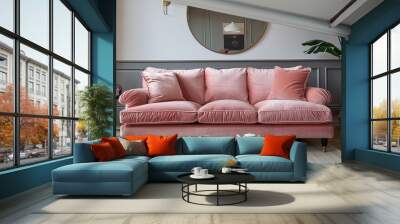 Blush pink velvet three-seater sofa with brass legs in a modern living room, featuring a large wall mirror, black side table, plant, and white coffee table with books, teapot, and two glasses of tea. Wall mural