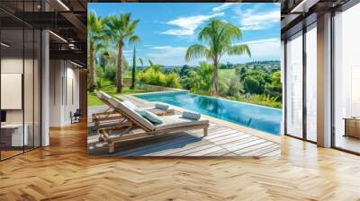 Two sunbeds on wooden deck by the pool in modern garden with palm trees, green grass, blue sky, and sunny day in South France. Wall mural