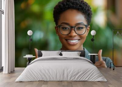 Young African American woman thumbs up in front of the camera Wall mural