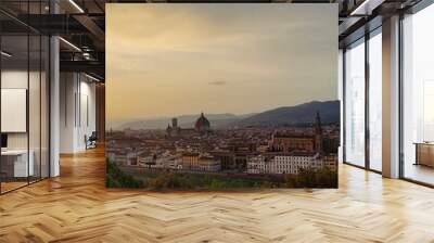 Sunsets over Florence! The terracotta dome of the Duomo crowns the city bathed in golden light. Visitors admire the view from a terrace, their silhouettes contrasting the vibrant sky. Wall mural