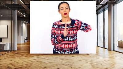 Young beautiful Arab woman wearing Christmas sweater against white wall feels tired and bored, making a timeout gesture, needs to stop because of work stress, time concept. Wall mural