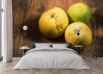 Beautiful yellow and green ripe Pomelo fruit isolated on a rustic wooden table.  Wall mural