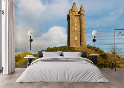 Panoramic view of a path leading to an old hilltop castle tower under a blue sky with white puffy clouds Wall mural