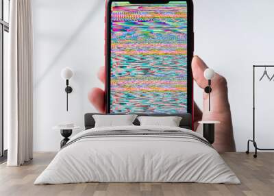 A hand holding smartphone, mobile phone closeup. Glitches, distorted, corrupted image with colorful lines on the phone. Color channels effect.
 Wall mural