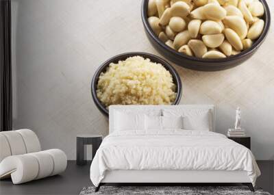 Close up of ground garlic and stacked peeled raw garlic on two black bowls and cloth floor, South Korea
 Wall mural