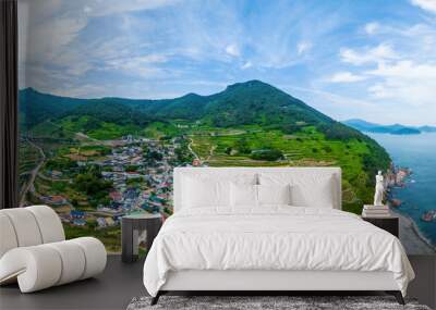 Nam-myeon, Namhae-gun, Gyeongsangnam-do, South Korea - June 18, 2023: Aerial and summer view of road and houses of Daraengi Village with terraced rice paddy under mountain near the sea
 Wall mural