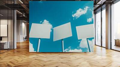 Image of five blank white road signs pointing in different directions against a bright blue sky with scattered clouds Wall mural