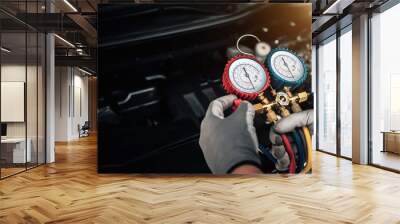 Hand of car mechanic technician use meter to check car air conditioner system heat problem and fix repairing and filling air refrigerant. Wall mural