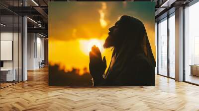 Handsome bearded man praying at sunset. Praying concept. Wall mural