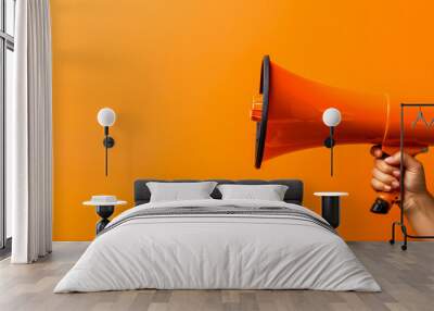 orange megaphone in woman hand on a orange background, copy space, hiring, advertising, announce, ba Wall mural