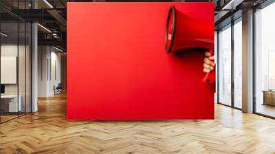 red megaphone in woman hand on a red background, copy space, hiring, advertising, announce, banner c Wall mural