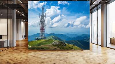 A tall tower with a red and white stripe on it is on top of a hill. The sky is blue and there are clouds in the background. Concept of height and power, as well as a connection to nature Wall mural