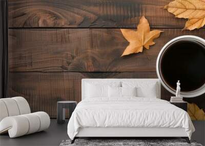 Hot cup of coffee on a wooden table with fall leaves, cozy, seasonal Wall mural