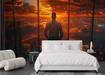 A silhouette of a man gazing at a stunning sunset from a high-rise building, overlooking a vibrant city skyline. Wall mural