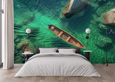 Aerial view of a serene turquoise lake with crystal clear water, featuring a single wooden boat surrounded by rocks and lush green foliage. Wall mural