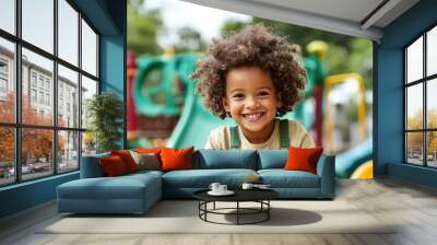 Happy child playing in a playground, smiling and enjoying outdoor fun. Wall mural