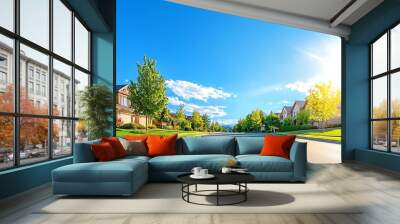 A picturesque suburban street lined with trees and homes under a clear blue sky at sunrise, perfect for serene living. suburban development concept. Wall mural