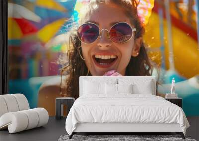 Happy girl enjoying colorful drink at water park, radiating joy and excitement.  Wall mural