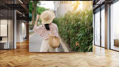 Portrait of asian young woman traveler with weaving hat and basket happy smile on green public park nature background. Journey trip lifestyle, world travel explorer or Asia summer tourism concept. Wall mural