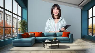 young enterpriser manager, asian working woman holding tablet and smiling, standing over green background Wall mural