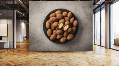 Almonds in chocolate coated in cocoa in bowl on dark table. Top view. Wall mural