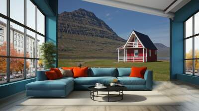 Traditional red painted wooden panel house with mighty Holmatindur mountain in the background in Eskifjordur, East Iceland Wall mural