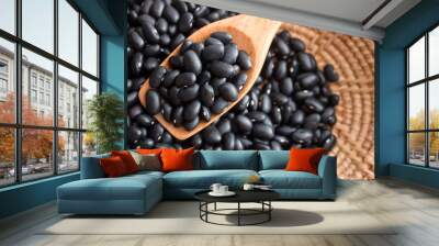 Raw black beans in basket and spoon on wood table. Wall mural