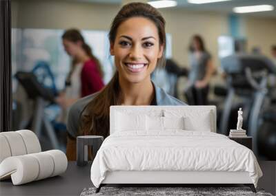 A portrait of a Hispanic female physical therapist in an outpatient physical therapy clinic with patients on exercise equipment in the background. Wall mural