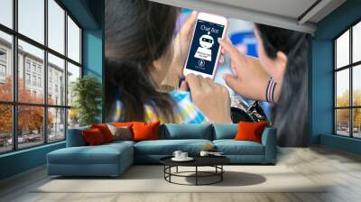 2 girls,Hand holding smartphone artificial intelligence, Is starting to learn AI chat bot concept. Wall mural