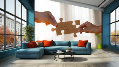 Business concept. Close up of hands connecting two pieces of jigsaw puzzle over the beautiful sunset Wall mural