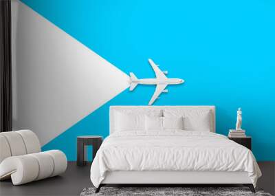 Flat lay of miniature toy airplane on white and yellow background. Travel items on a blue background. Wall mural